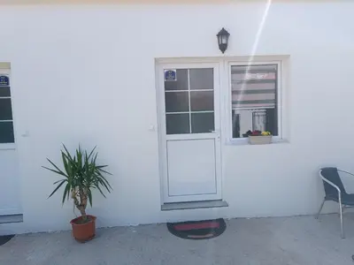 a white house with a window and a plant at Adamovic in Pirot