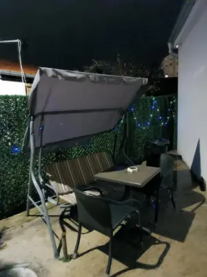 a table and chairs under an umbrella on a patio at Adamovic in Pirot