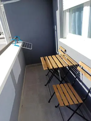 two benches and a table in a room with a window at Apartman NALE in Vrnjačka Banja