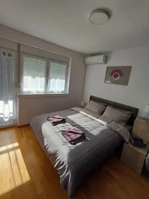 a bedroom with a large bed with two towels on it at Apartman NALE in Vrnjačka Banja