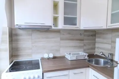 a kitchen with white cabinets and a stove and a sink at Apartman Ivanka in Soko Banja