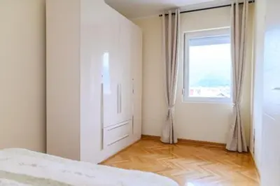 a bedroom with a door and a window and a wooden floor at Apartman Ivanka in Soko Banja