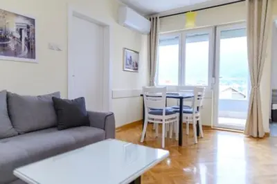 a living room with a couch and a table with chairs at Apartman Ivanka in Soko Banja