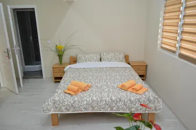 a bedroom with a bed with two orange pillows on it at Guest House Konak Iris in Predejane