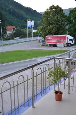 a red truck driving down a road next to a fence at Guest House Konak Iris in Predejane