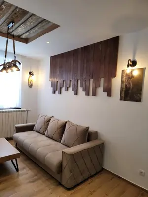 a living room with a brown couch in a room at MASSIV Kopaonik centar lux apartmani in Kopaonik