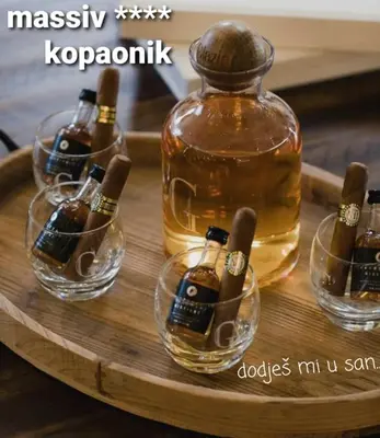 a tray with bottles and glasses of whiskey on it at MASSIV Kopaonik centar lux apartmani in Kopaonik