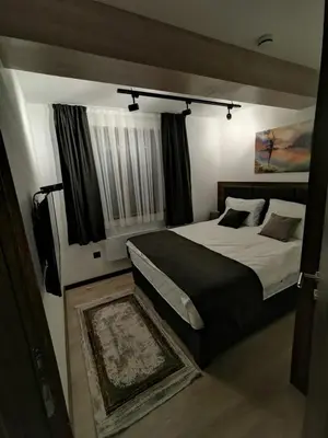 a bedroom with a large bed and a window at Ice Dream Apartmani in Kopaonik