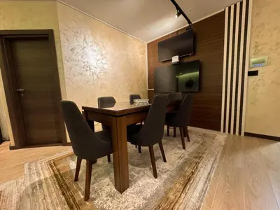 a dining room with a wooden table and chairs at Ice Dream Apartmani in Kopaonik