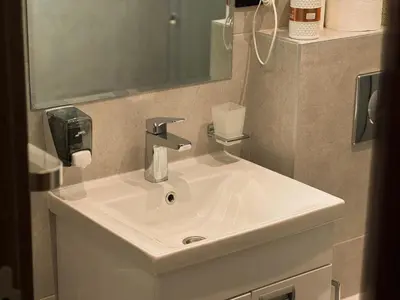 a bathroom with a white sink and a mirror at Ice Dream Apartmani in Kopaonik