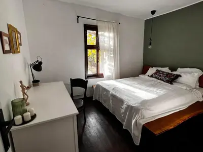 a bedroom with a bed and a desk and a window at Sentina kuća in Vrtovac