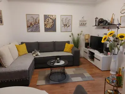 a living room with a gray couch and yellow pillows at Viva Lux in Soko Banja