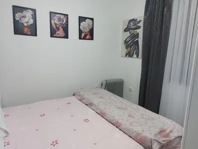 a bed in a bedroom with pictures on the wall at Viva Lux in Soko Banja
