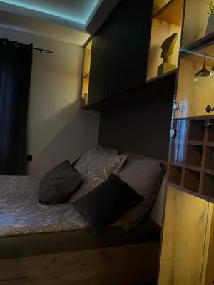 a small bedroom with a bed and a cabinet at Beta Lux in Zaječar