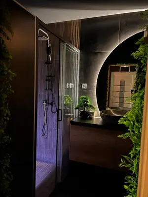 a bathroom with a shower with a plant and a mirror at Beta Lux in Zaječar