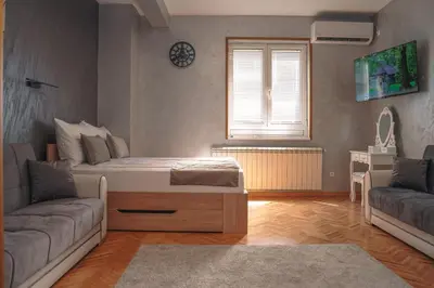 a living room with a bed and a couch at Dukat Apartmani-Studio in Vrnjačka Banja