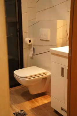 a white bathroom with a toilet and a sink at Dukat Apartmani-Studio in Vrnjačka Banja
