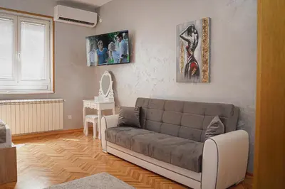 a living room with a couch and pictures on the wall at Dukat Apartmani-Studio in Vrnjačka Banja