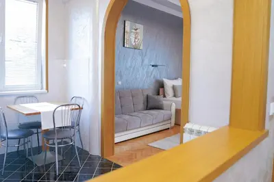 a living room with a couch and a table and a mirror at Dukat Apartmani-Studio in Vrnjačka Banja