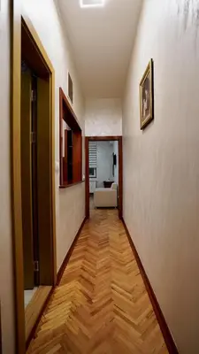 a hallway with a wooden floor in a room at Dukat Apartmani-Studio in Vrnjačka Banja