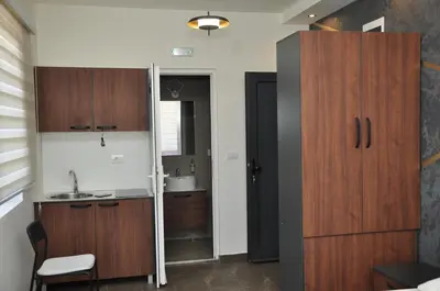 a kitchen with wooden cabinets and a sink at Nego apartmani in Kuršumlija