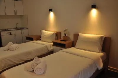 two beds in a hotel room with towels on them at Nego apartmani in Kuršumlija