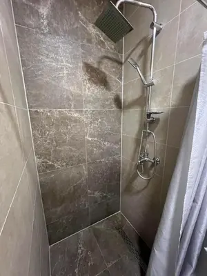 a shower with a glass door in a bathroom at Nego apartmani in Kuršumlija
