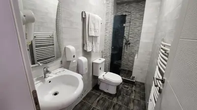 a white bathroom with a sink and a toilet at Hotel Rile Men Blue in Niš