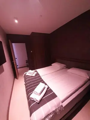 a bedroom with a bed with two towels on it at Woodside RENT Kopaonik in Kopaonik