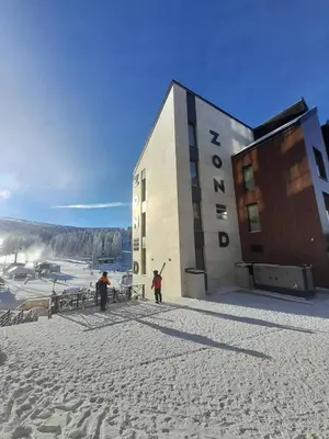 two people standing outside of a building in the snow at Woodside RENT Kopaonik in Kopaonik