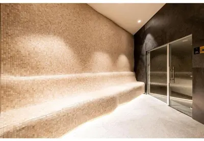 a bathroom with a walk in shower next to a wall at Woodside RENT Kopaonik in Kopaonik