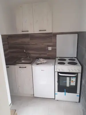 a white kitchen with a stove and a sink at Apartman Leggiero in Vrnjačka Banja