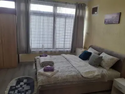 a bedroom with a large bed and a window at Apartman Leggiero in Vrnjačka Banja