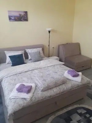 a bedroom with a large bed with towels on it at Apartman Leggiero in Vrnjačka Banja