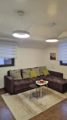 a living room with a brown couch and a table at Apartman Treska Kop in Kopaonik