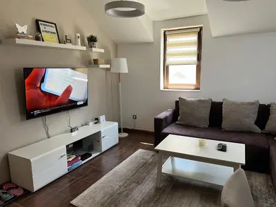 a living room with a couch and a flat screen tv at Apartman Treska Kop in Kopaonik