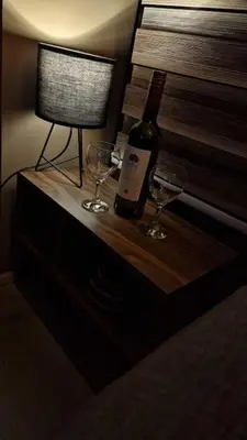 a bottle of wine and two glasses on a dresser at Supreme studio in Niš