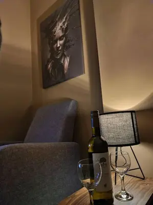 a bottle of wine sitting on a table with a glass at Supreme studio in Niš