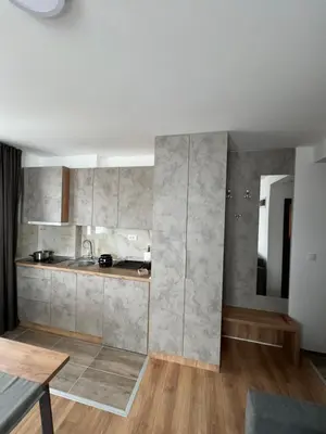 a kitchen with concrete walls and wooden floors and a table at Apartments SKY Kopaonik in Kopaonik