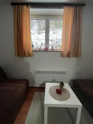 a living room with a coffee table and a window at Apartman Cogan - 100m from Gondola - Brzece in Kopaonik