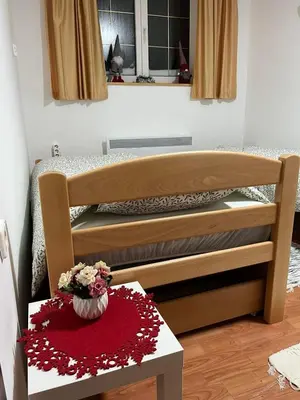 a bedroom with a bed and a table with flowers at Apartman Cogan - 100m from Gondola - Brzece in Kopaonik