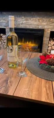a bottle of wine and two glasses on a wooden table at Vidik Dream Kopaonik in Kopaonik
