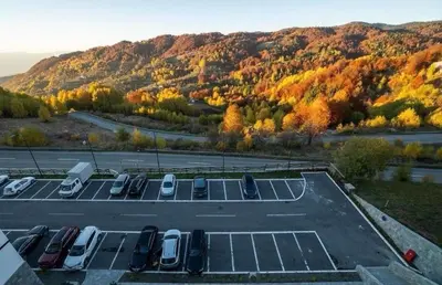 a parking lot with a bunch of parked cars at Vidik Dream Kopaonik in Kopaonik
