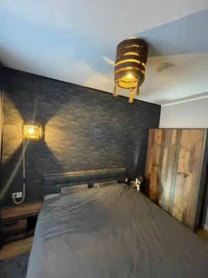a bedroom with a bed with a brick wall at Vidik Dream Kopaonik in Kopaonik