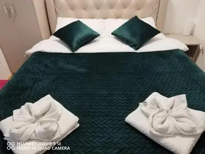 a bed with green and white towels on it at Apartman Rajčić in Vrnjačka Banja
