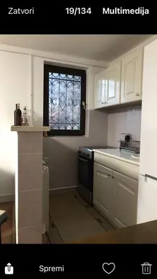 a kitchen with white cabinets and a window in it at GOČ Planinska Kuća MILJA in Kraljevo