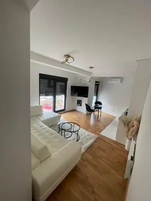 a living room with a white couch and a table at Apartment in Vila dr Milovan in Vrnjačka Banja