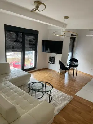 a living room with a white couch and a table at Apartment in Vila dr Milovan in Vrnjačka Banja
