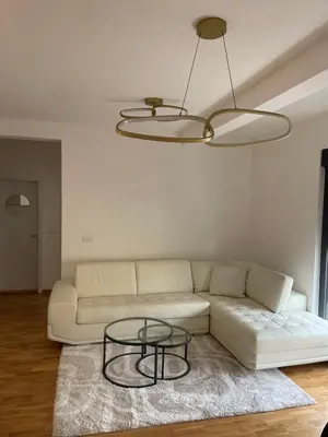 a living room with a white couch and a glass table at Apartment in Vila dr Milovan in Vrnjačka Banja