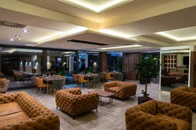 a restaurant with couches and tables and chairs at Hotel & Restaurant Ponte Bianco in Vranje